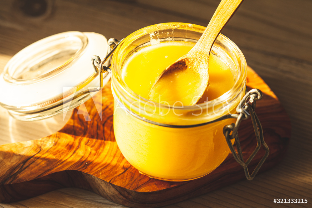 Wooden spoon with ghee - clarified butter on the kitchen