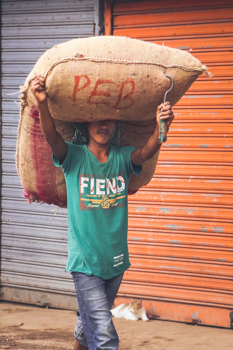 a man carrying a large sack on his head