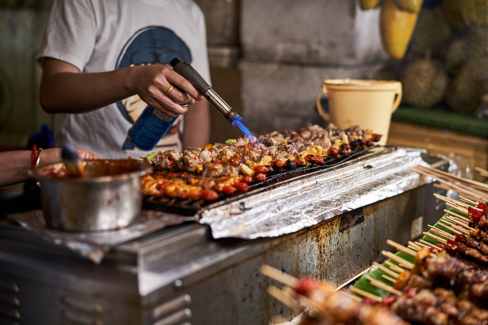 a person cooking food on a grill with tongs