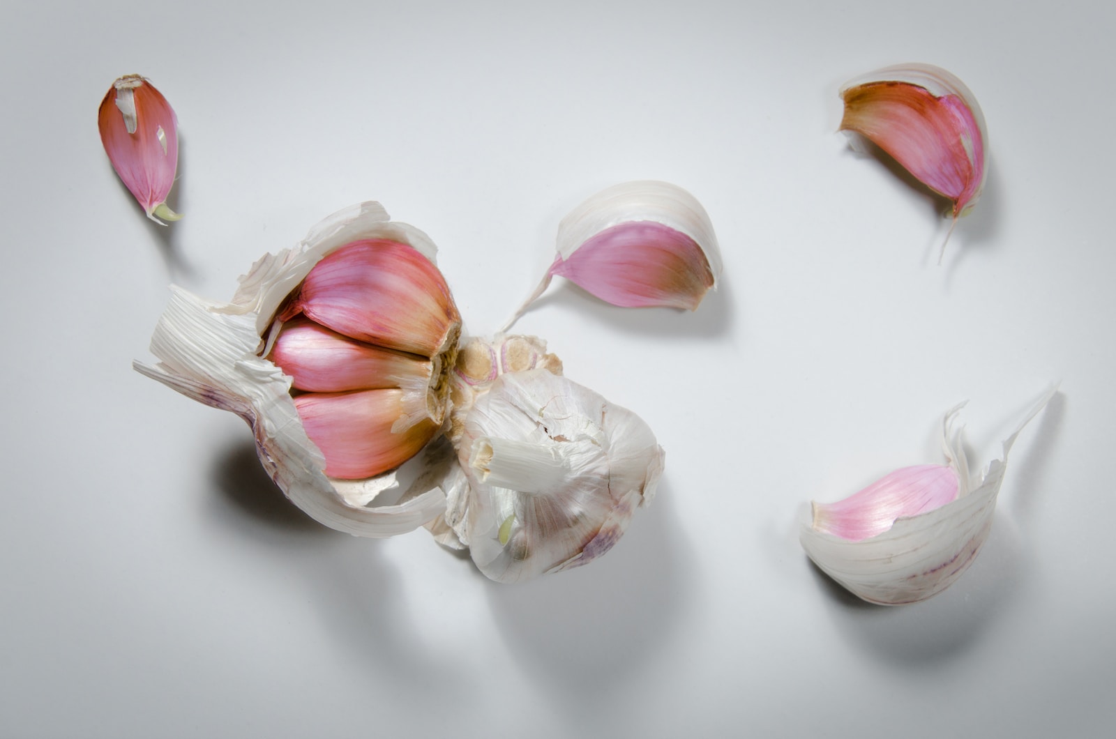 white and pink garlic on white surface